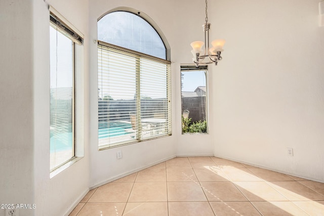 unfurnished dining area featuring light tile patterned floors and a notable chandelier