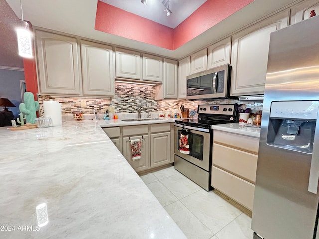 kitchen with stainless steel appliances, sink, tasteful backsplash, light tile patterned flooring, and pendant lighting