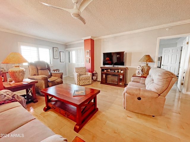 living room with ceiling fan, a textured ceiling, light wood-type flooring, and crown molding