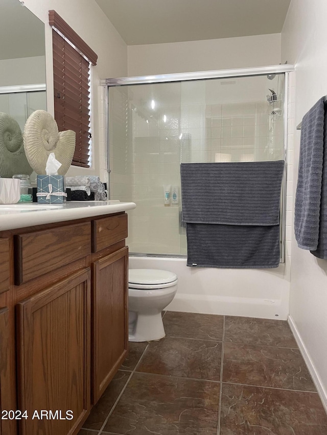 full bathroom featuring bath / shower combo with glass door, vanity, and toilet