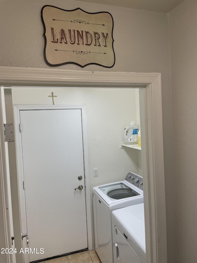 clothes washing area with washing machine and clothes dryer and light tile patterned floors