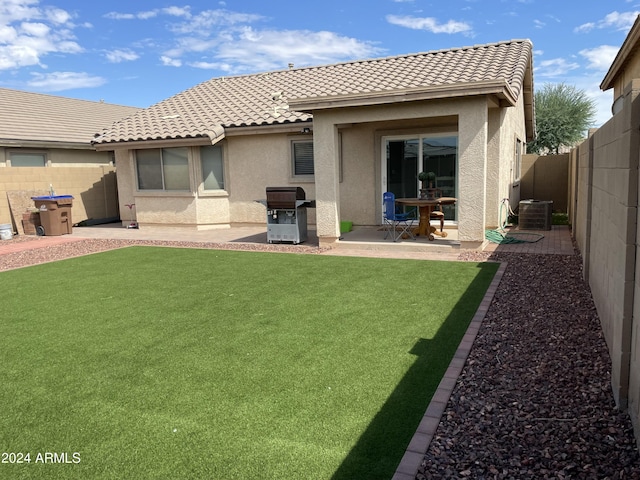 back of property featuring a lawn, central air condition unit, and a patio