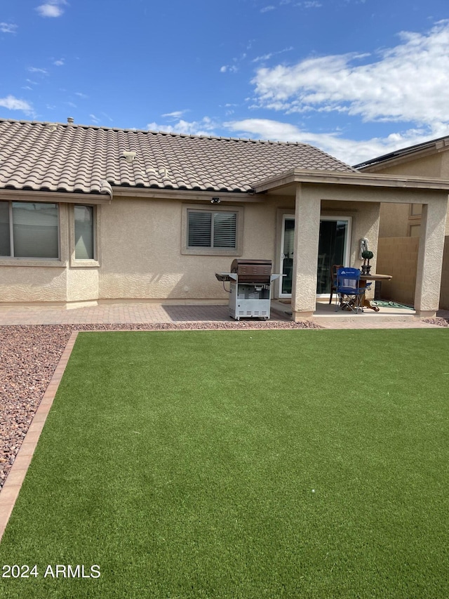 back of house with a yard and a patio area