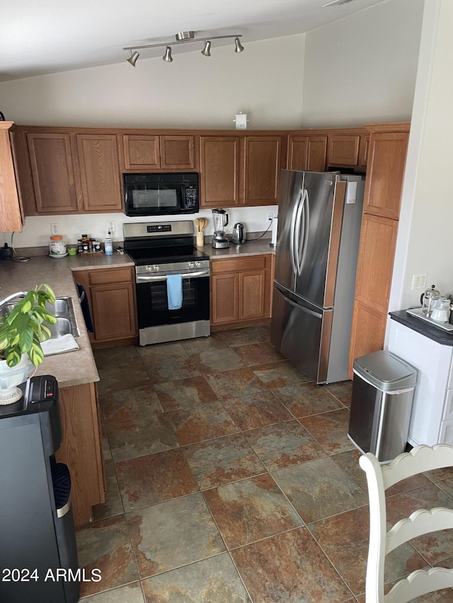 kitchen featuring stainless steel appliances, sink, and vaulted ceiling