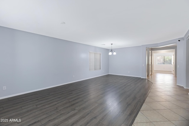 43232 W Magnolia Rd, Maricopa, AZ 85138 - empty room with a chandelier, baseboards, and wood finished floors