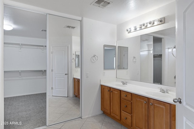 43232 W Magnolia Rd, Maricopa, AZ 85138 - bathroom featuring tile patterned flooring, double vanity, baseboards, and a walk in closet
