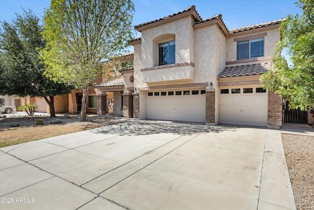 43232 W Magnolia Rd, Maricopa, AZ 85138 - mediterranean / spanish-style house with a tiled roof, an attached garage, stucco siding, concrete driveway, and stone siding