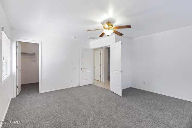 43232 W Magnolia Rd, Maricopa, AZ 85138 - unfurnished bedroom featuring carpet flooring, a walk in closet, baseboards, and ceiling fan