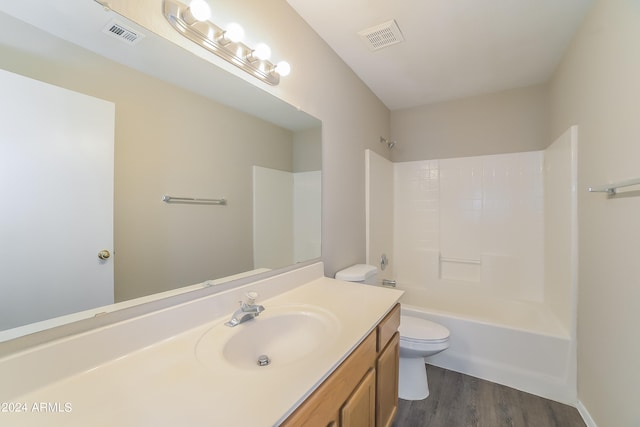 full bathroom featuring washtub / shower combination, vanity, hardwood / wood-style flooring, and toilet