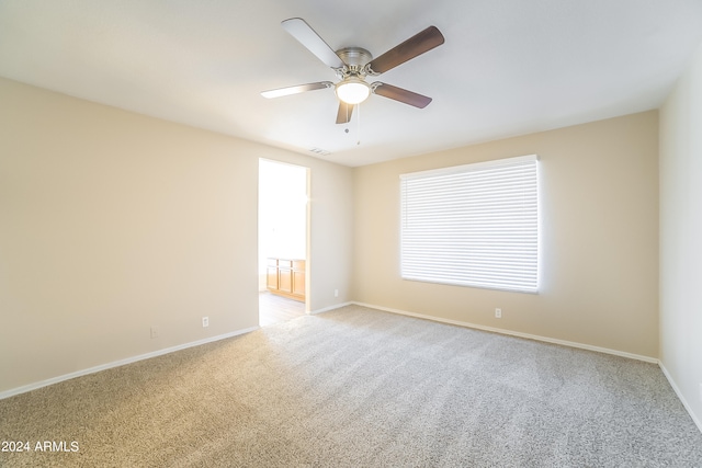 carpeted spare room featuring ceiling fan