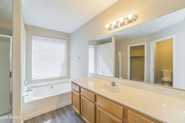 full bathroom featuring hardwood / wood-style flooring, vanity, separate shower and tub, and toilet