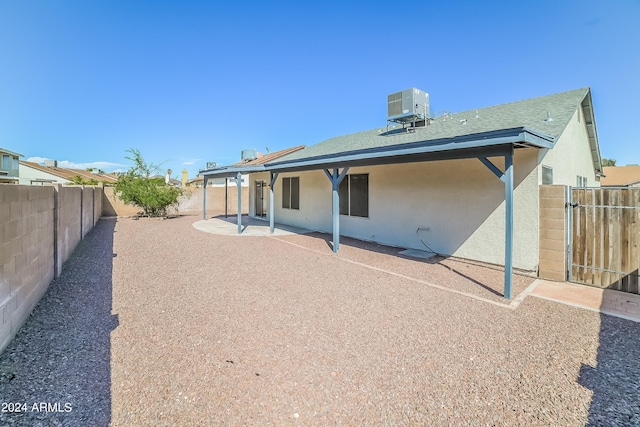 rear view of house with central AC unit and a patio