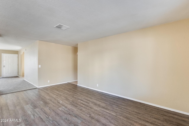 spare room featuring a textured ceiling and hardwood / wood-style flooring