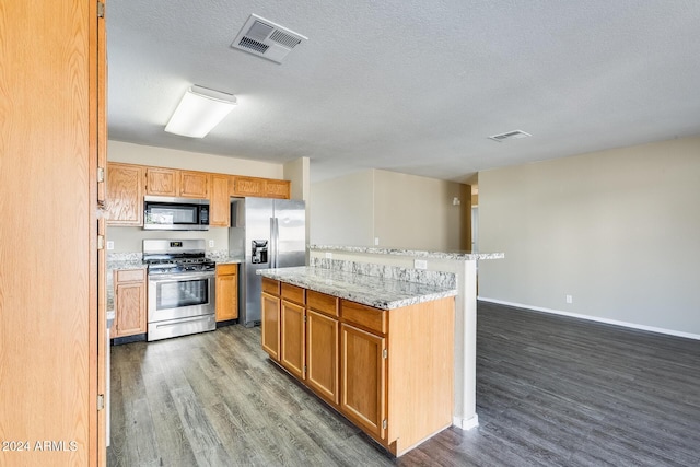 kitchen with dark hardwood / wood-style floors, light stone countertops, a textured ceiling, and appliances with stainless steel finishes