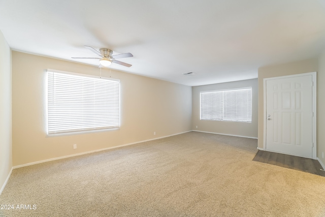 carpeted spare room with ceiling fan