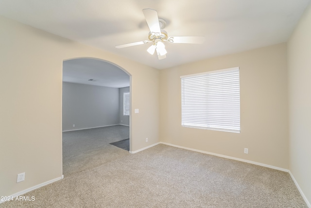 carpeted spare room with ceiling fan