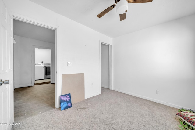 unfurnished room featuring light carpet, washing machine and clothes dryer, and ceiling fan