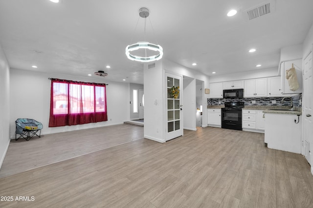 kitchen with sink, white cabinetry, decorative light fixtures, light hardwood / wood-style flooring, and black appliances