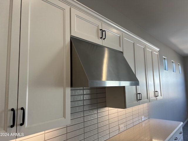 interior details featuring tasteful backsplash and white cabinetry