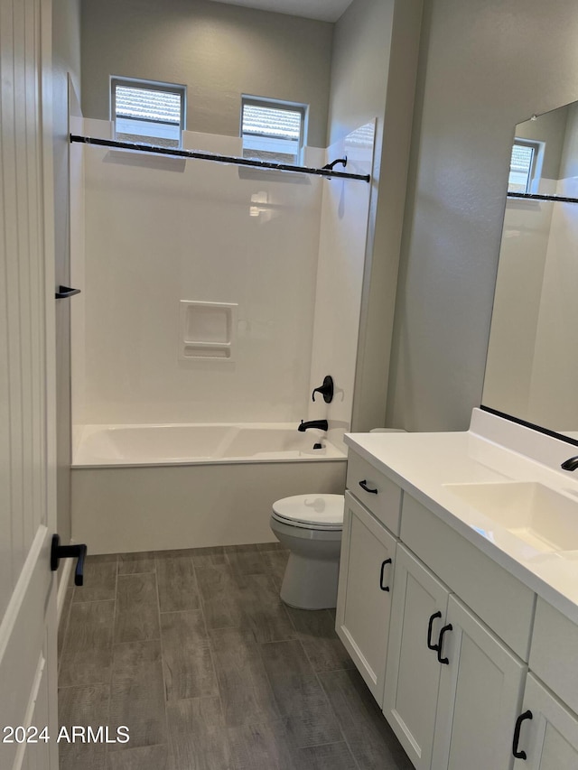 full bathroom with bathing tub / shower combination, vanity, wood-type flooring, and toilet