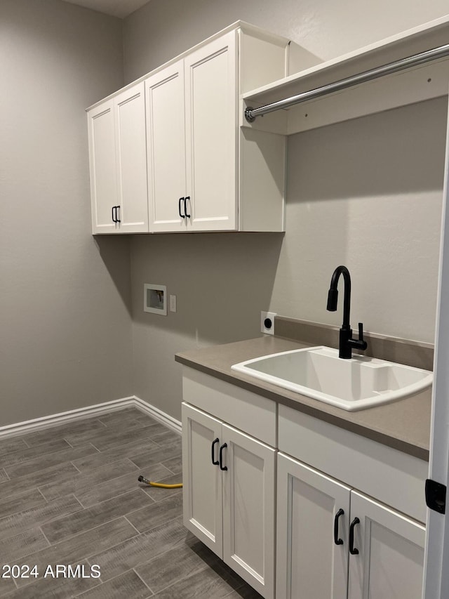 laundry area with cabinets, washer hookup, hookup for an electric dryer, sink, and dark hardwood / wood-style floors