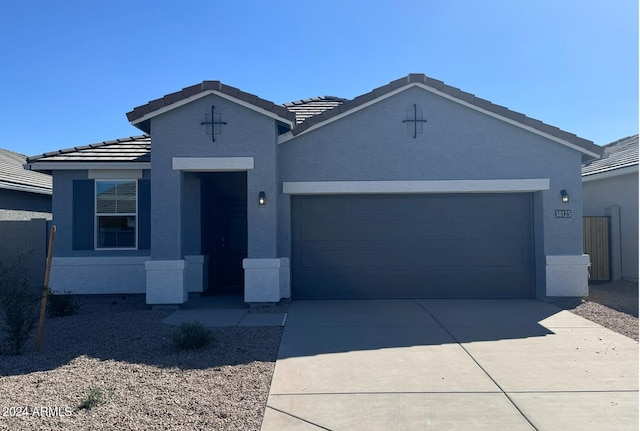 single story home featuring a garage, driveway, and stucco siding