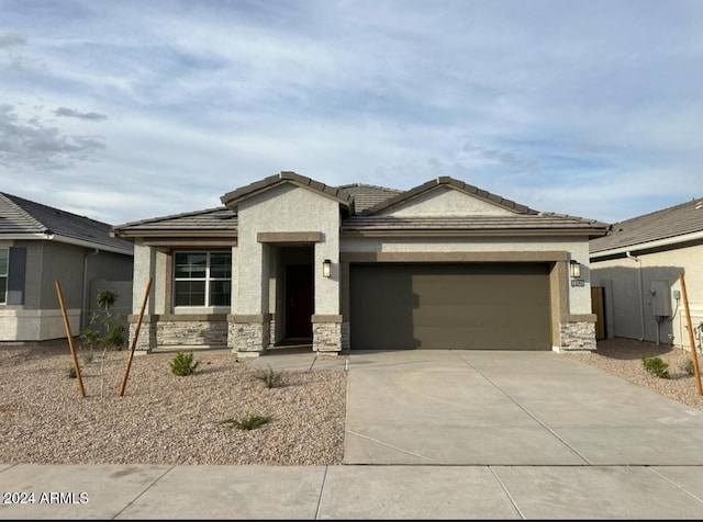 38120 W Excussare Way, Maricopa, AZ 85138 - view of front of home featuring driveway, a garage, stone siding, and a tile roof