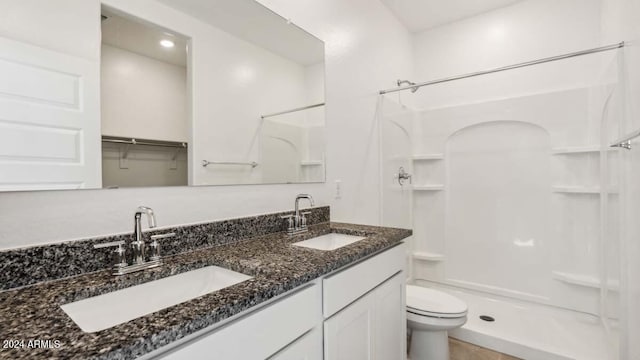 bathroom featuring vanity, toilet, and walk in shower