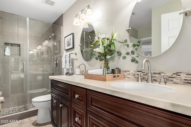 bathroom featuring backsplash, tile patterned floors, an enclosed shower, vanity, and toilet