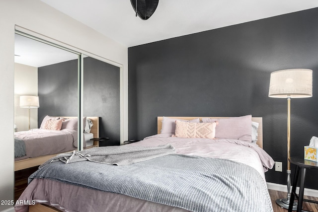 bedroom with wood-type flooring and a closet