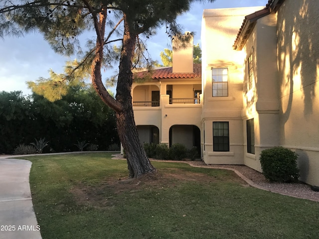 view of front of home featuring a balcony and a front yard