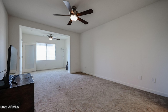 unfurnished living room featuring a ceiling fan, baseboards, and light carpet