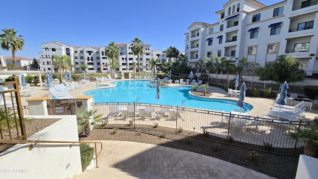 community pool with a patio and fence