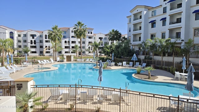community pool with fence and a patio area