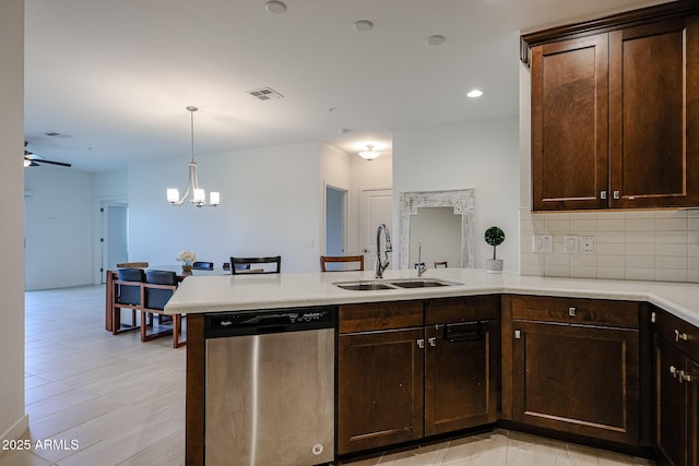 kitchen with a sink, a peninsula, backsplash, stainless steel dishwasher, and visible vents