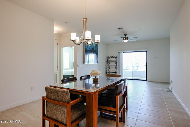 dining space featuring baseboards, visible vents, light tile patterned floors, and ceiling fan with notable chandelier