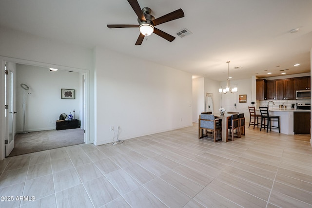 living area with visible vents, recessed lighting, baseboards, and ceiling fan with notable chandelier