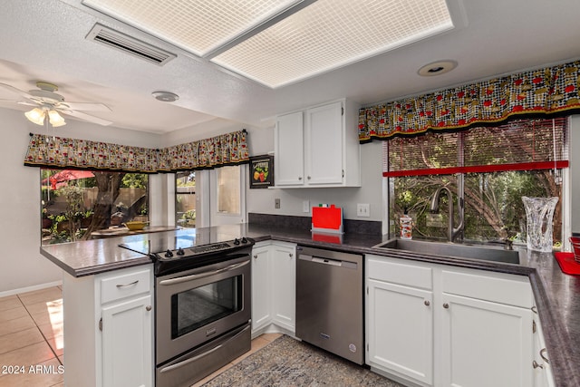 kitchen featuring white cabinets, kitchen peninsula, sink, and stainless steel appliances