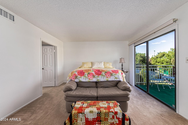 bedroom with access to outside, a textured ceiling, and light carpet