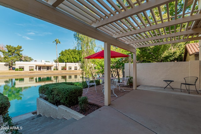 view of patio / terrace featuring a water view and a pergola