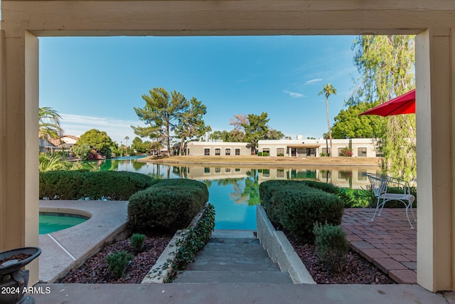 view of pool with a water view and a patio area