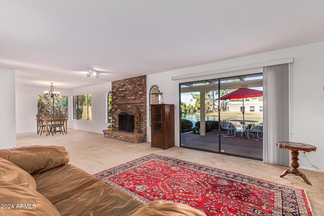 living room with a fireplace, a chandelier, and carpet floors