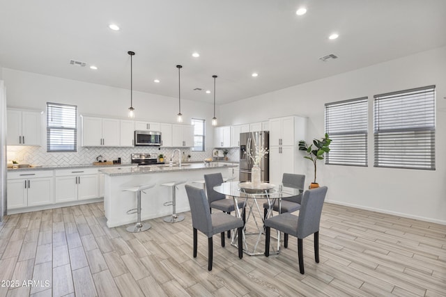 15718 W Polk St, Goodyear, AZ 85338 - dining space featuring light wood finished floors and recessed lighting