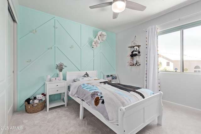 carpeted bedroom featuring baseboards, ceiling fan, and multiple windows