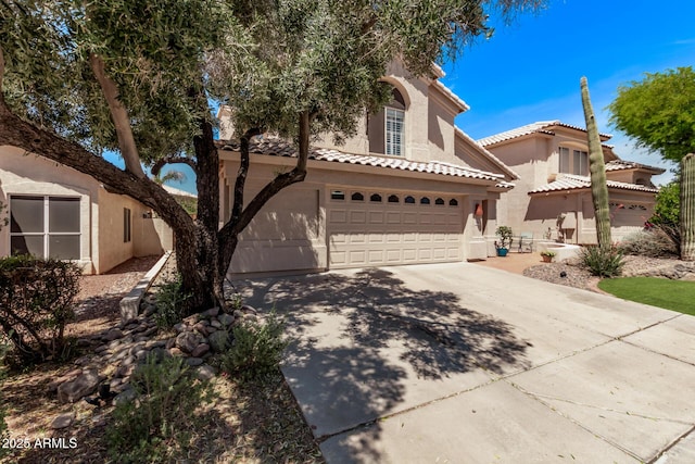 view of front of property featuring an attached garage, stucco siding, driveway, and a tile roof