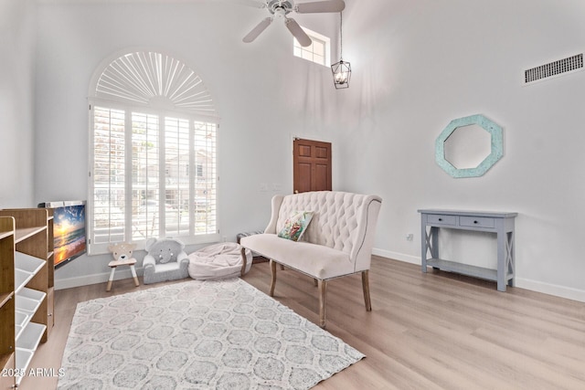 sitting room with visible vents, a ceiling fan, and a wealth of natural light