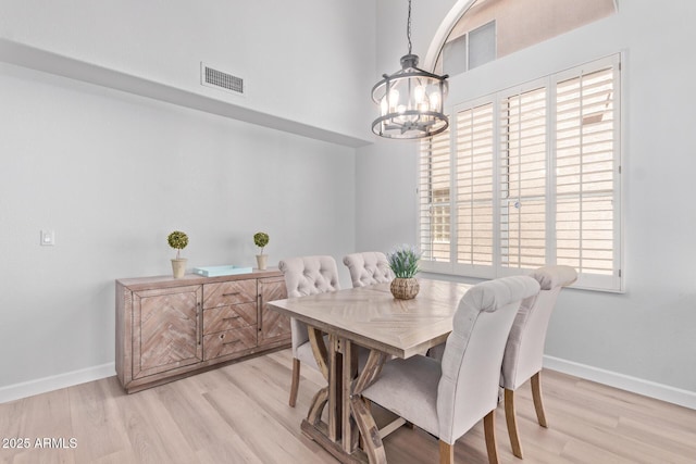 dining area featuring a chandelier, baseboards, visible vents, and light wood-style floors
