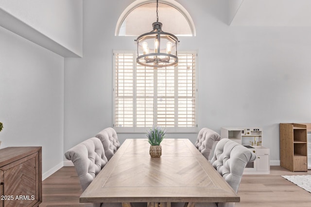dining space with light wood-style floors, baseboards, and a chandelier