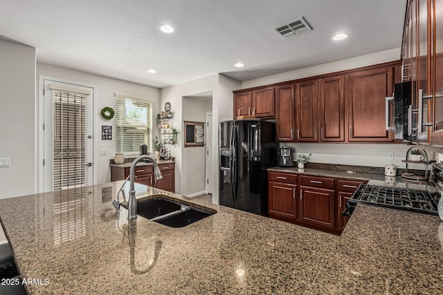 5437 W Red Bird Rd, Phoenix, AZ 85083 - kitchen with black refrigerator with ice dispenser, range with gas stovetop, dark stone counters, stainless steel microwave, and recessed lighting