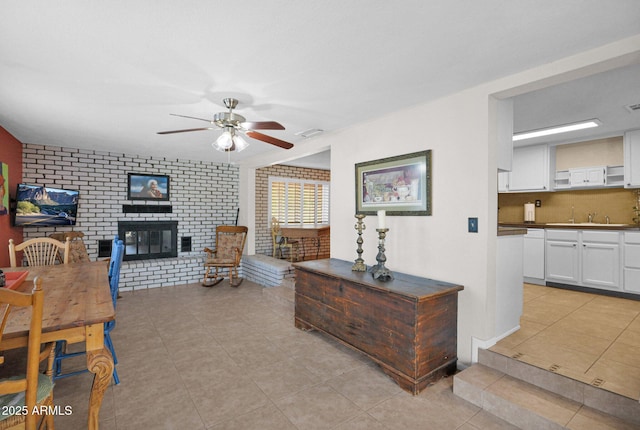 living area with visible vents, a ceiling fan, light tile patterned flooring, and a fireplace